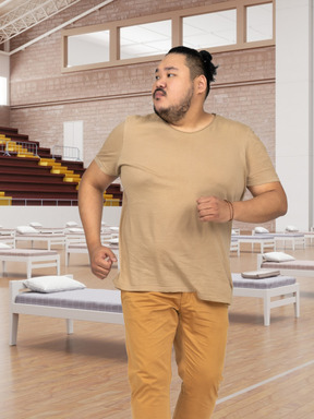 A man running in a room with beds
