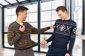 Dos jóvenes mostrando sus suéteres