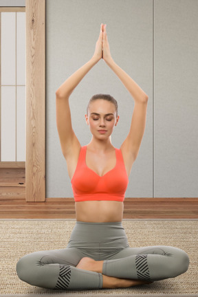 A woman in a red top is doing yoga