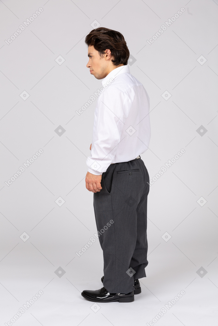 Vista lateral de um homem em trajes formais olhando para longe