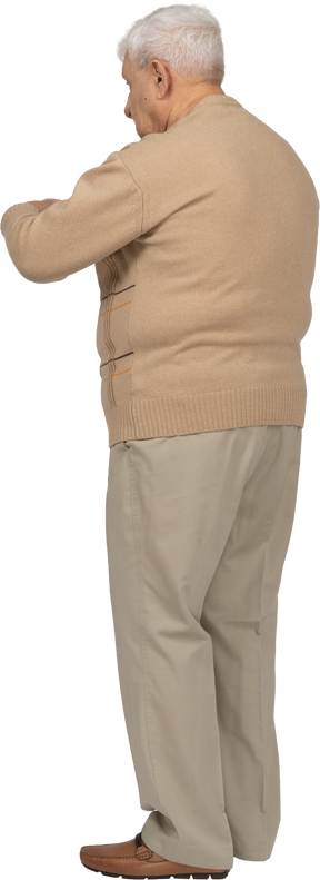 Vista laterale di un uomo anziano in abiti casual che punta con il dito