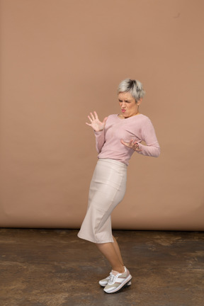 Vista lateral de una mujer emocional en ropa casual mostrando gesto de parada