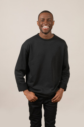 Young man smiling with his hands in the pockets