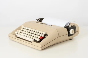 Beige typewriter on a white background