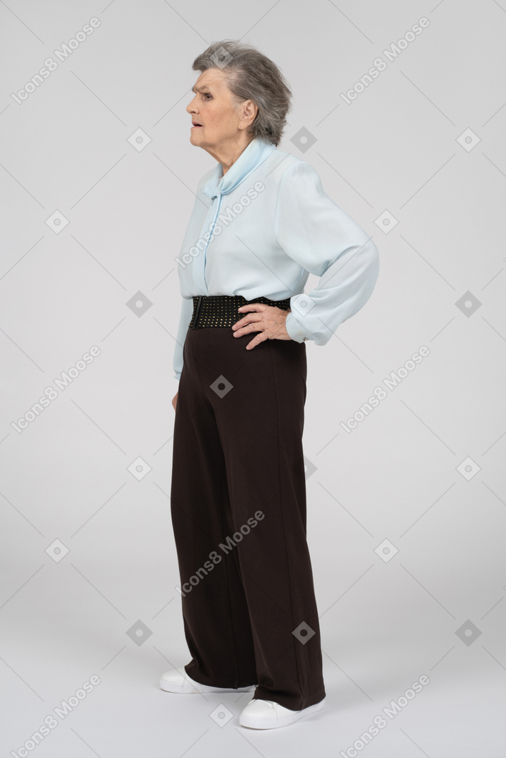 Three-quarter view of a puzzled old woman with a hand on a hip