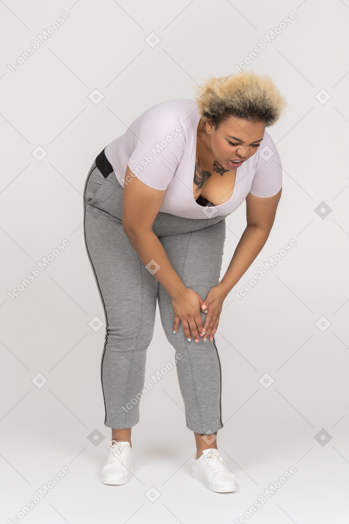Woman bending forward to touch her injured knee