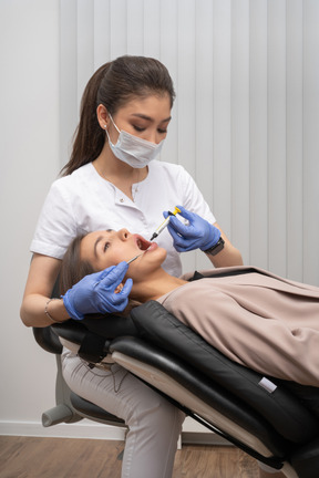 A woman getting her teeth checked by a dentist