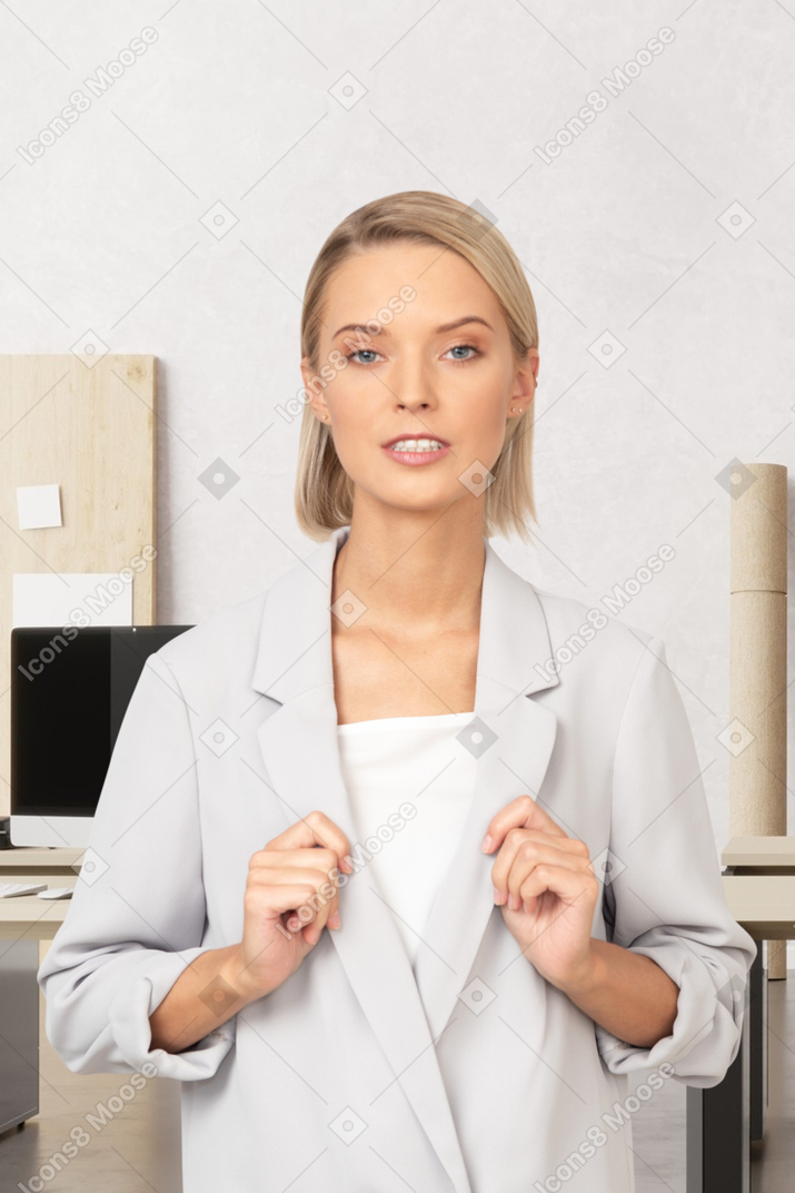 A woman in a white suit sitting at a desk