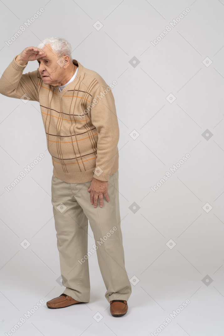 一位穿着休闲服的老人在寻找某人的正面图