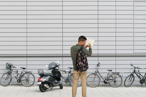 A man looking at a map in front of parked bicycles