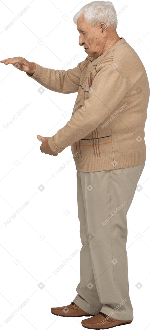 Vue latérale d'un vieil homme en vêtements décontractés montrant la taille de quelque chose
