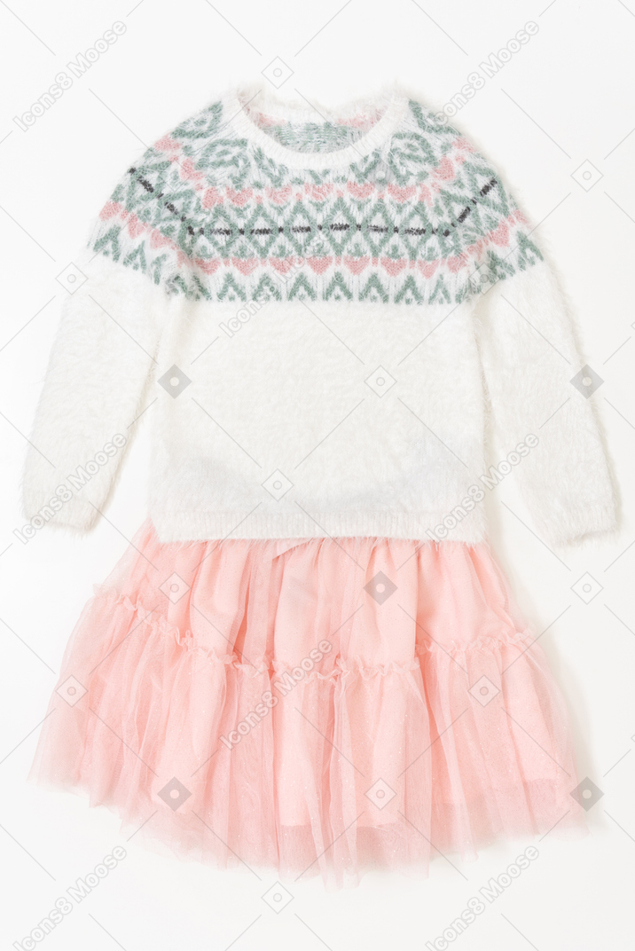 子供の女の子のピンクのスカートと白い背景の上の白いセーター