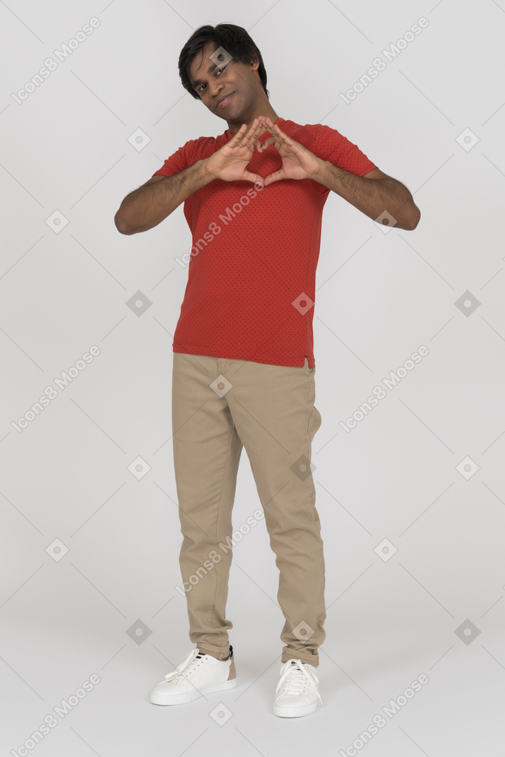 Young man showing heart gesture and smiling