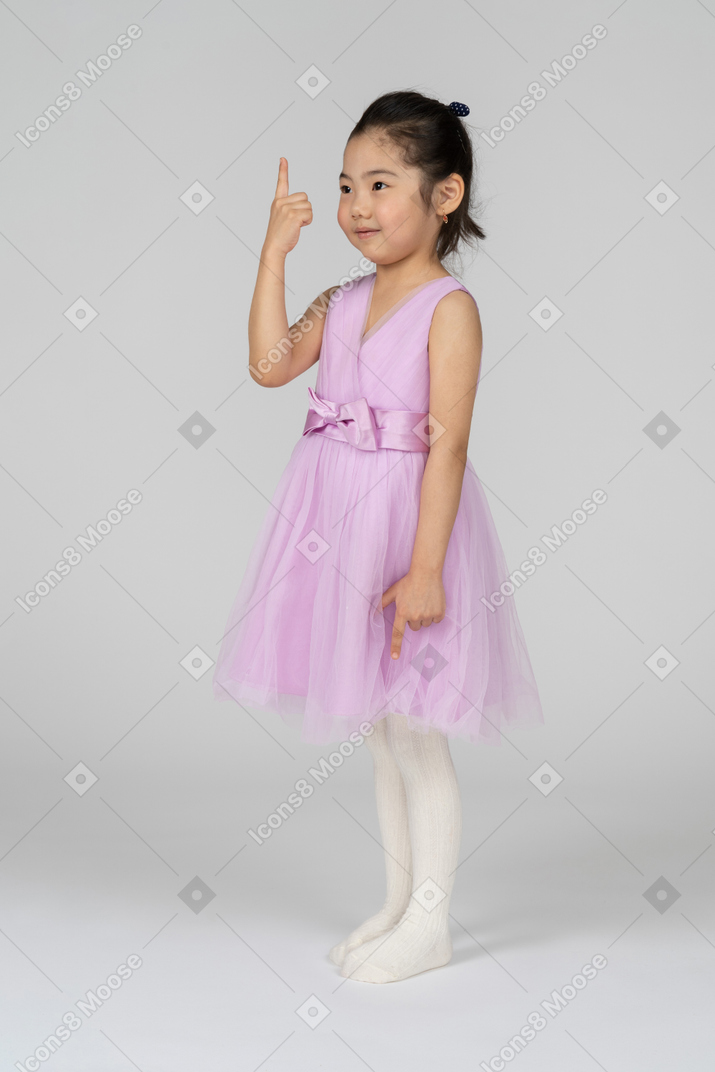 Portrait d'une petite fille pointant vers le haut