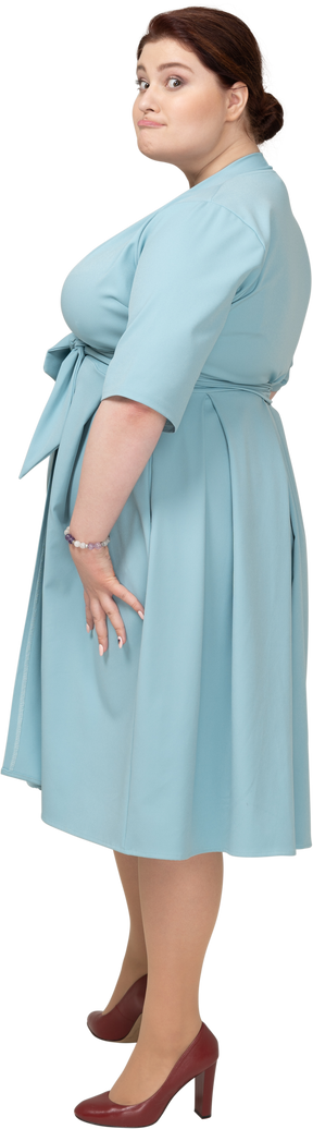 Mulher de vestido azul posando de perfil