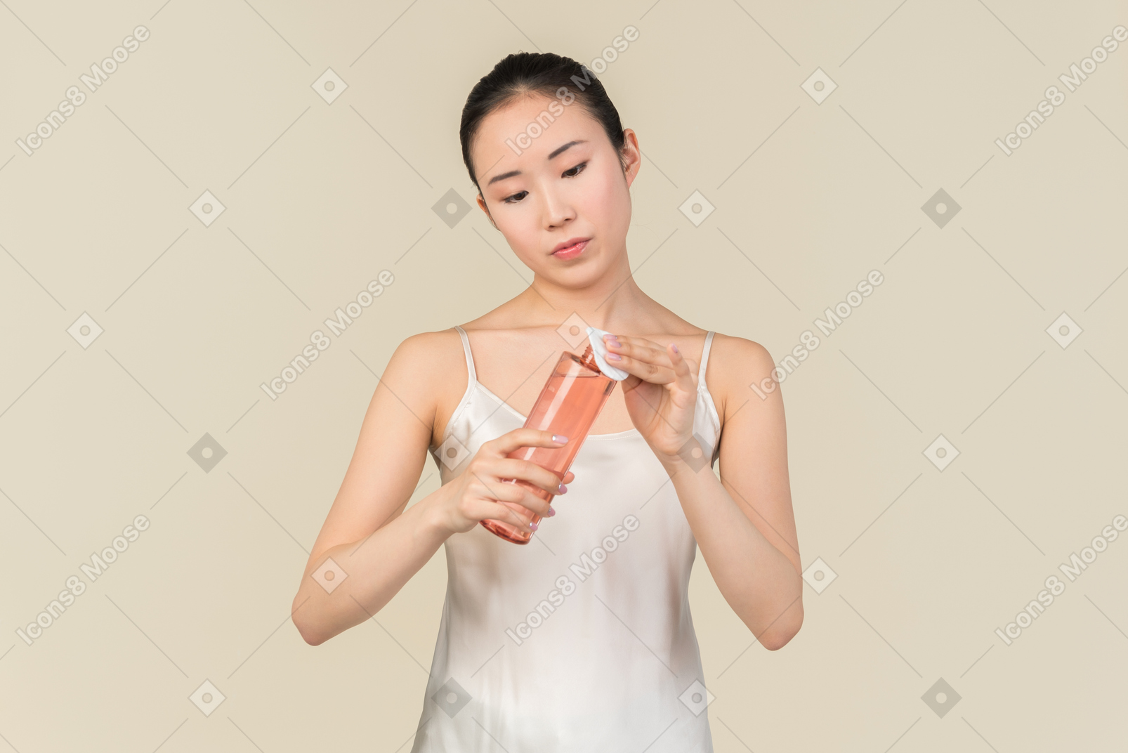 Young asian woman putting cosmetic product on cotton pad