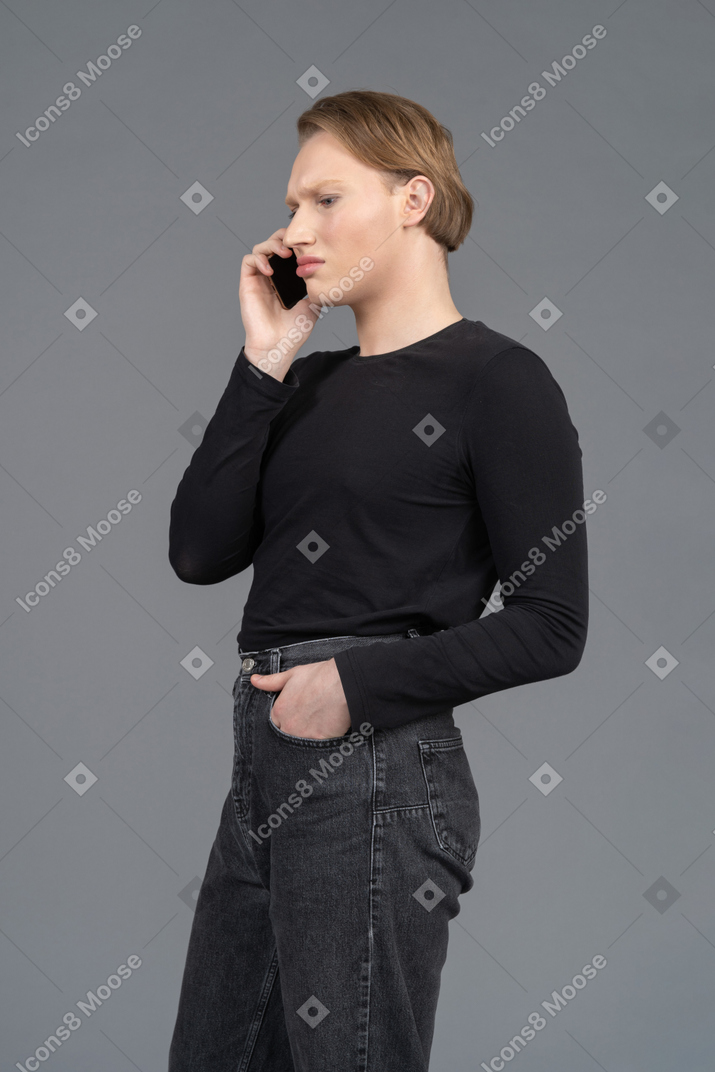Side view of a frowning person talking on the phone