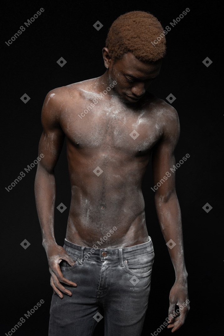 A portrait of an african man  standing with his torso all in flour
