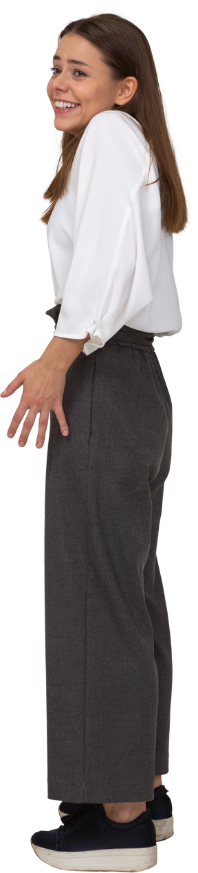 Vista di tre quarti di una giovane donna sorridente in abiti da ufficio che allarga le dita