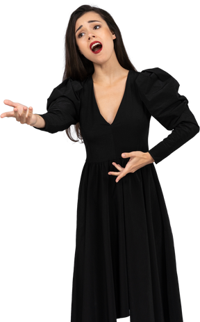 Vue de face d'une chanteuse d'opéra gesticulant en robe noire