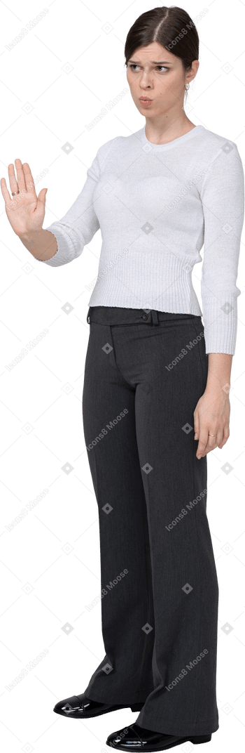 Vista de tres cuartos de una mujer joven en ropa de oficina extendiendo la mano