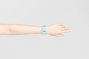 Relógio de mão azul na mão feminina