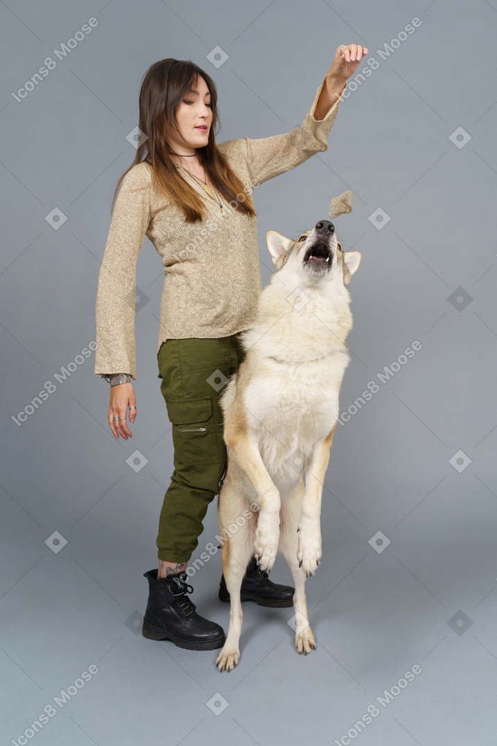Full-length of a female doctor training her dog