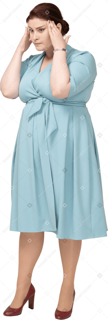 Vorderansicht einer frau im blauen kleid, die den kopf berührt