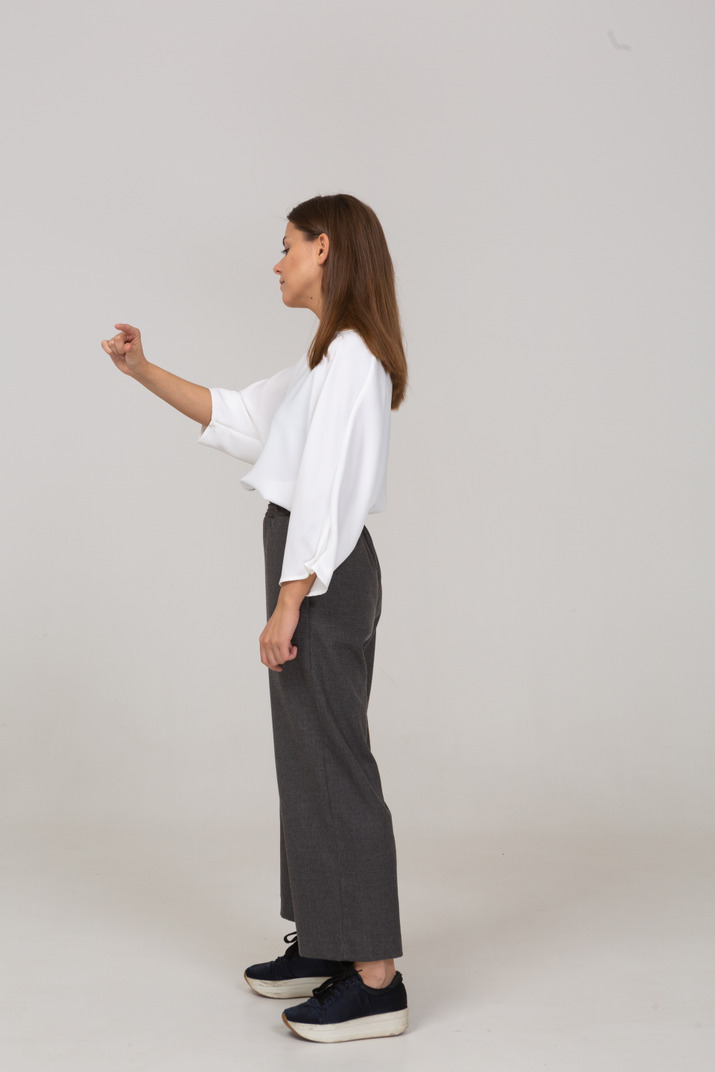 Side view of a young lady in office clothing showing a size of something