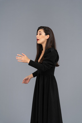Vista lateral de uma jovem cantora em um vestido preto