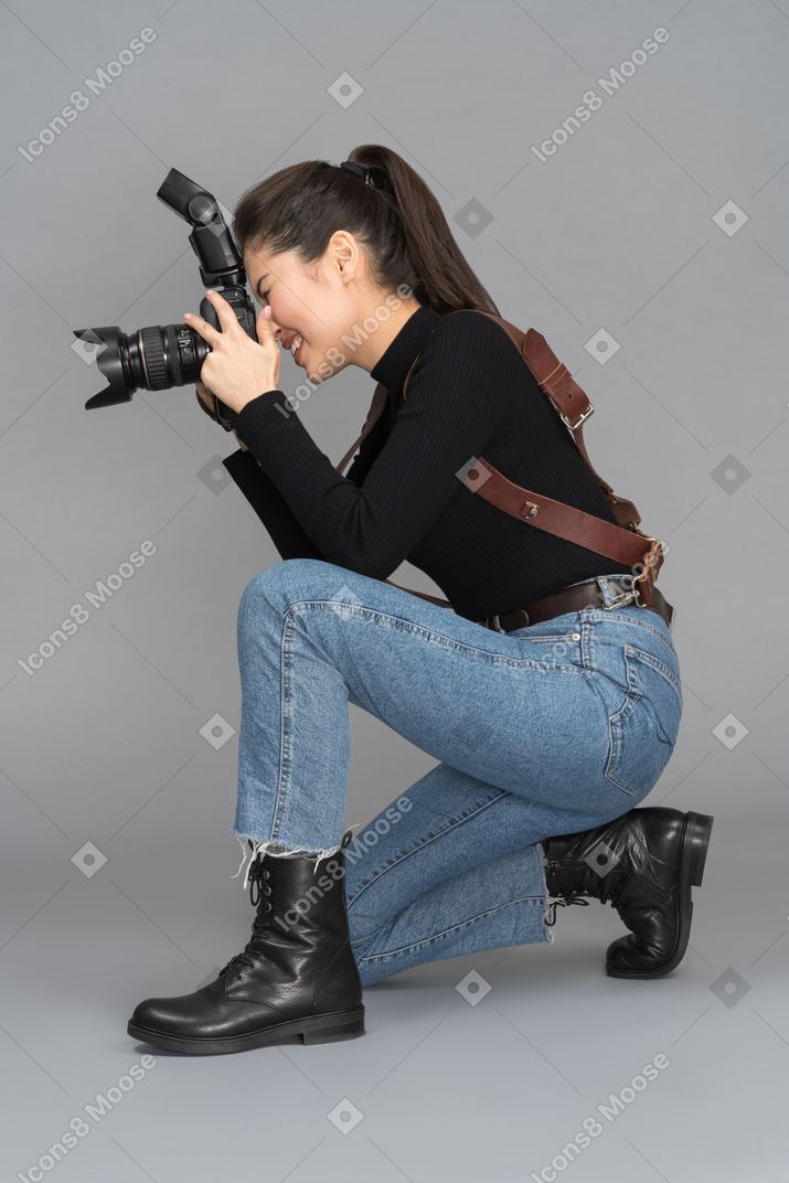 Female photographer staying on her knees while photo shooting