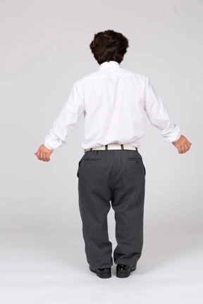 Young man with extended arms standing with his back toward the camera