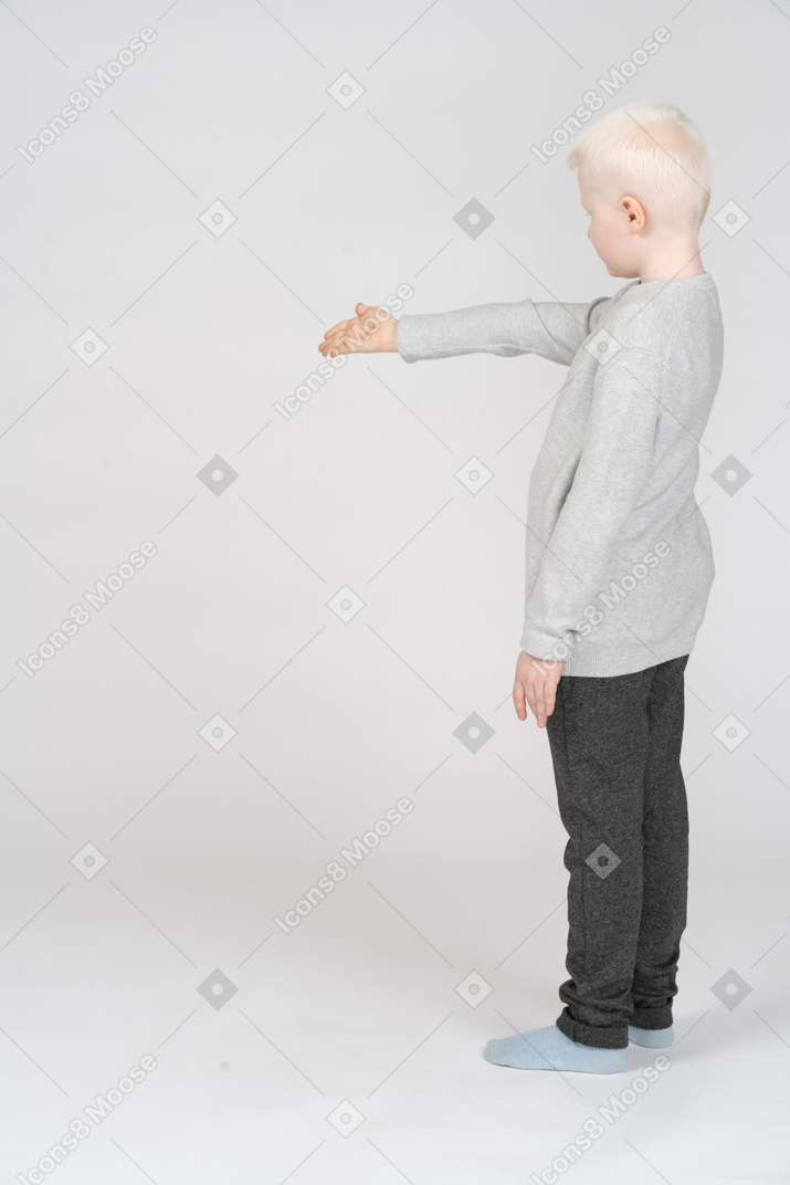 Side view of a boy holding out his hand