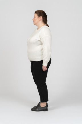Donna grassoccia in abiti casual in piedi di profilo