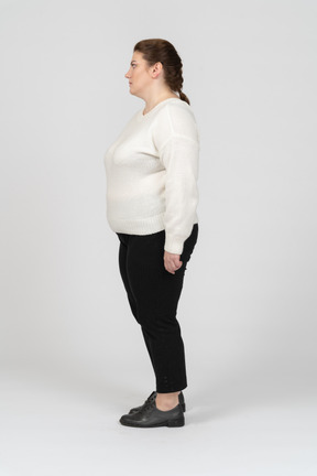 Plump woman in casual clothes standing in profile