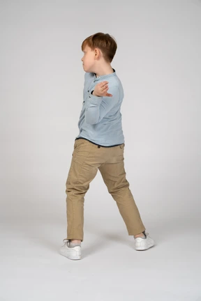 A boy standing in front of a wall