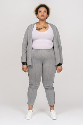 Portrait d'une femme afro tatouée en costume de sport gris