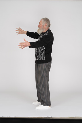 Side view of old man with hands outstretched