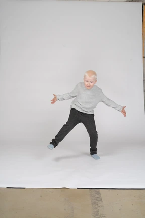 Front view of an upset boy shrugging his shoulders