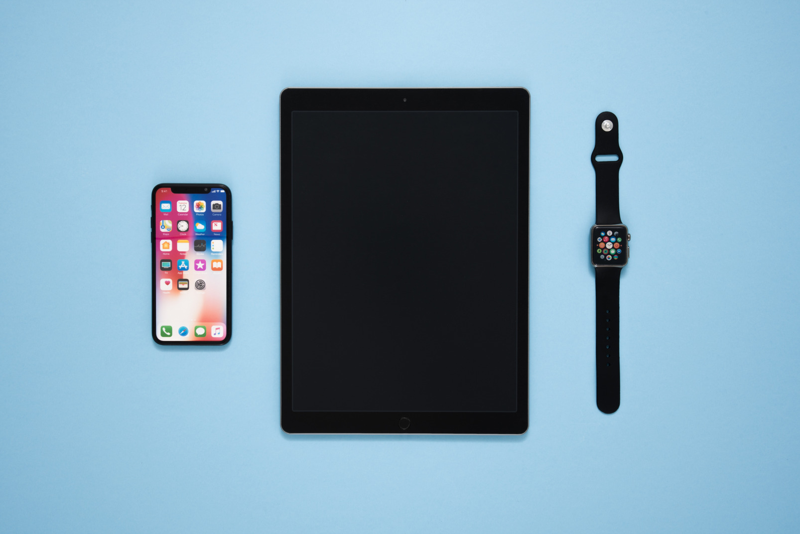 Digital tablet, smartphone and smartwatch over blue background