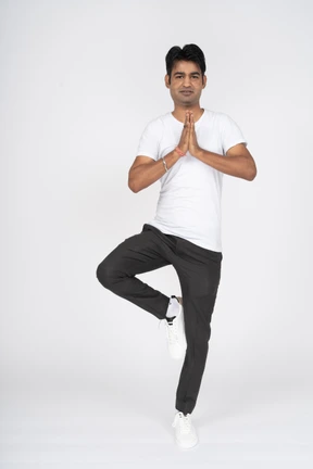 Hombre en camiseta blanca haciendo yoga