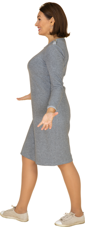 Vista laterale di una donna in abito grigio che gesticola