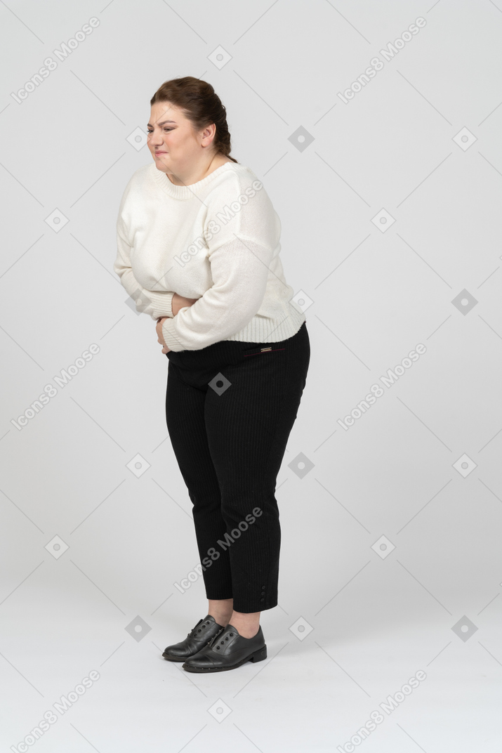 Plump woman in casual clothes suffering from stomach ache