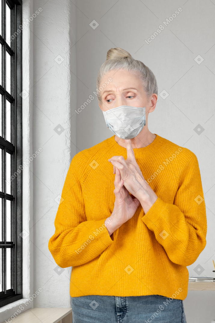 Worried elderly woman wearing a face mask