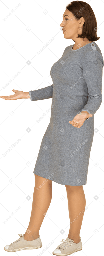 Vista laterale di una donna triste in abito grigio che gesticola