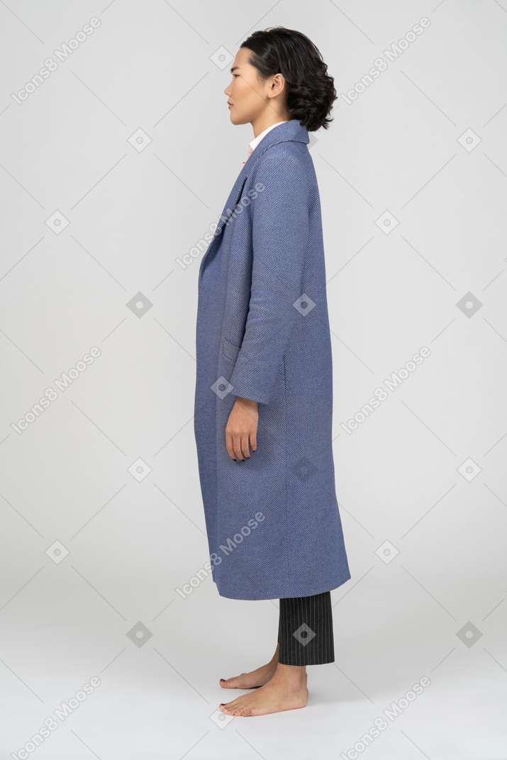 주름진 눈썹이 있는 파란색 코트를 입은 여성의 옆모습