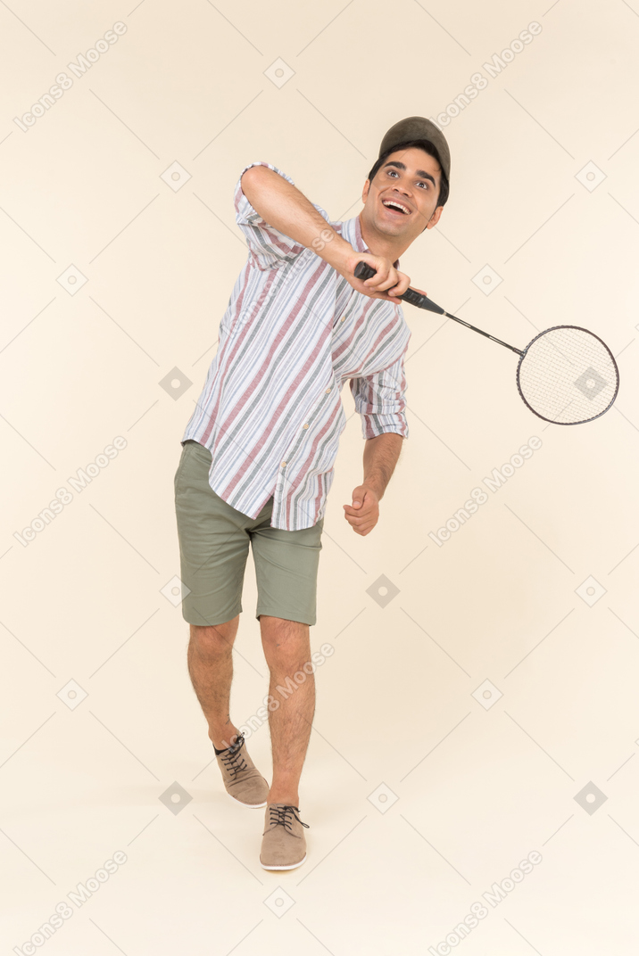 Laughing young caucasian man holding tennis racket