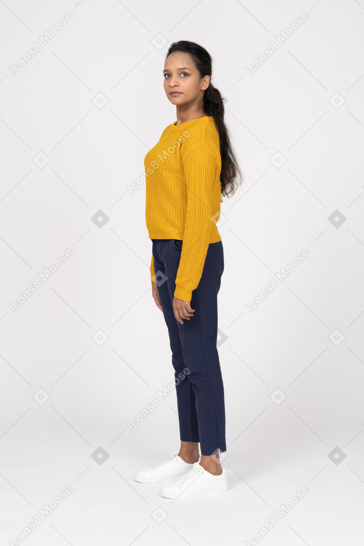 Side view of a girl in yellow shirt looking at camera