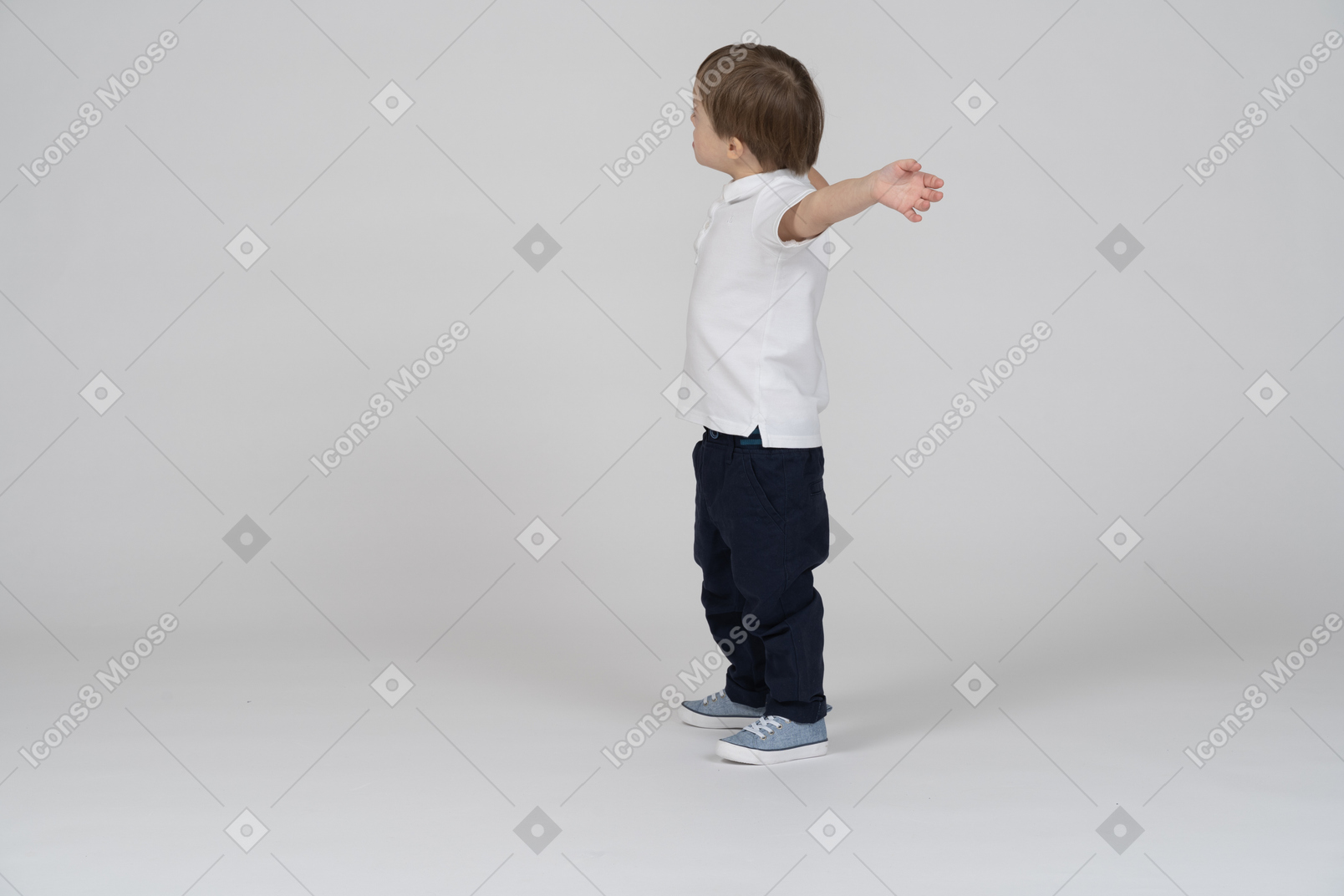 Vista lateral de un niño mirando hacia otro lado con las manos levantadas