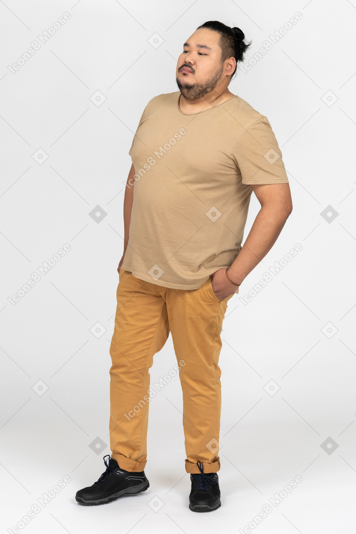 Thoughtful asian man holding hands in pockets